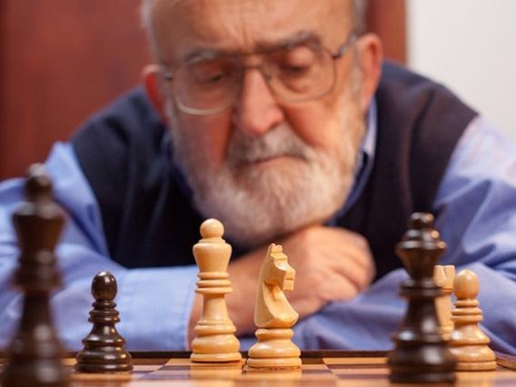 old male staring at the chess board